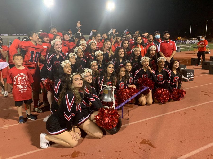 The Nitro football team and cheerleaders pose with the victory bell following their 39-8 win over Hoover.