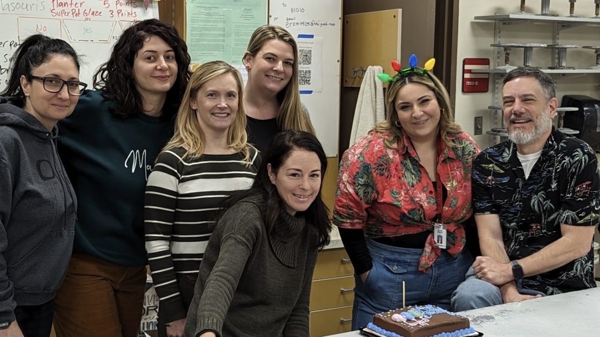 Mrs. Nicoleta Masouris (center, seated) celebrates her birthday with her devoted colleagues.